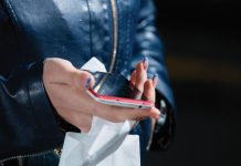 Mobile telefoon in de hand. Hand heeft lange gelakte nagels